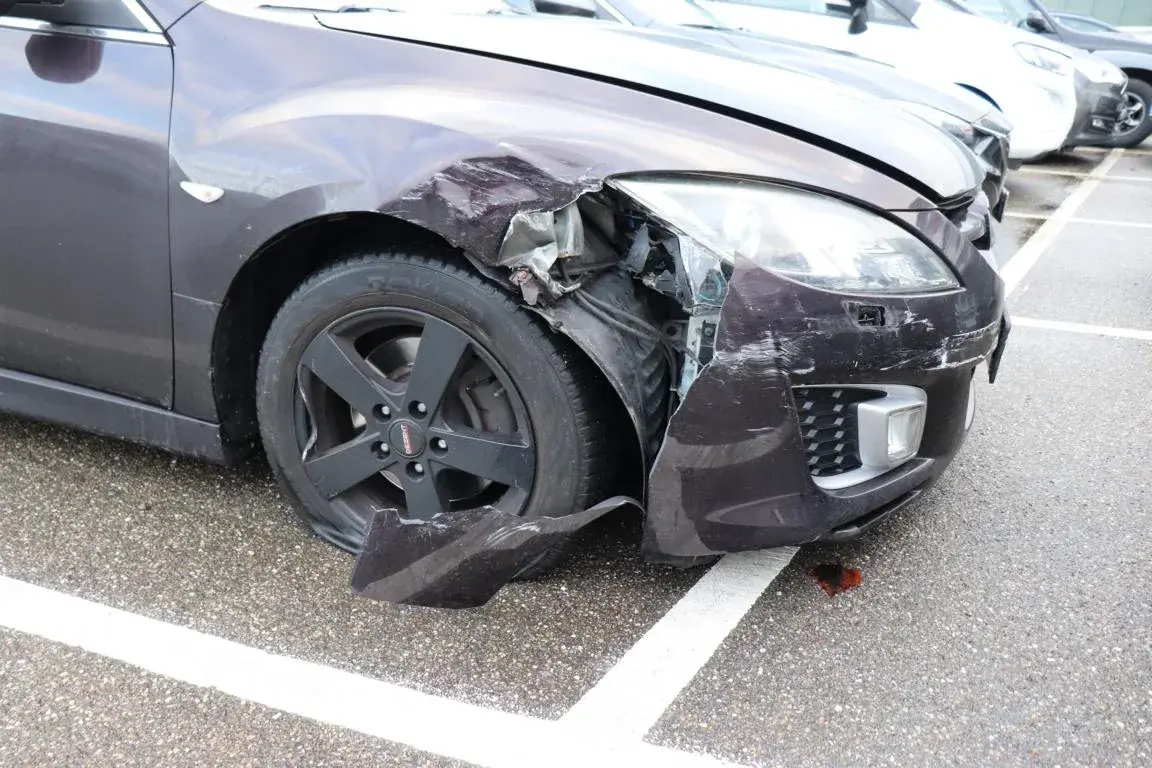 Beschädigter vorderer Kotflügel und Stoßfänger bei einer Kfz-Begutachtung