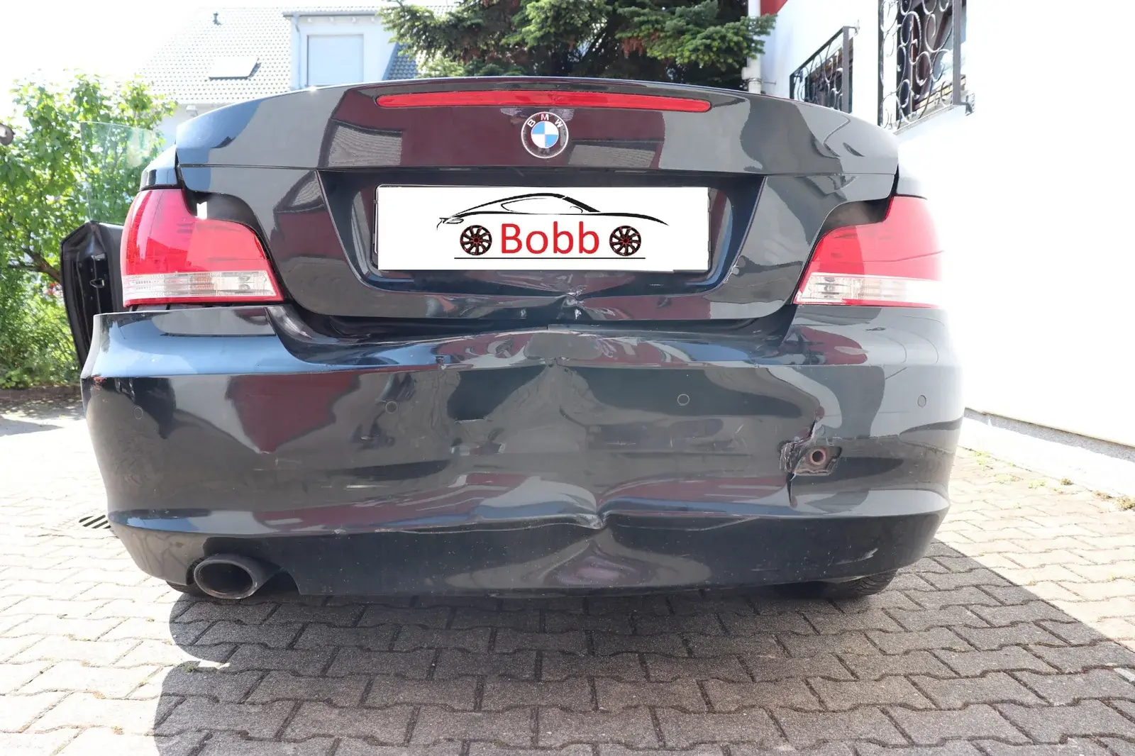 Heckschaden an einem dunklen Fahrzeug während einer Vor-Ort-Besichtigung
