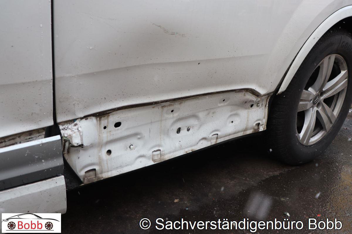 Beschädigter linker Unterholm und Türbereich des Audi Q7